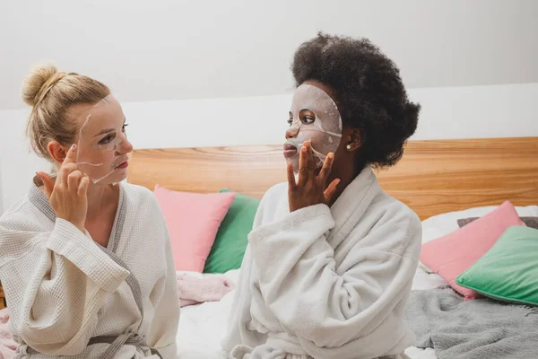 Dwie Młode Kobiety Maskach Siedzą Obok Zestawu Zabiegów Spa Kobiety — Zdjęcie stockowe