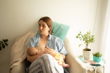 Anne ve bebek sandalyede. Beşikte emzirme pozisyonu