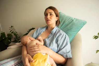 Yeni doğan bir bebeğin emzirilmesine yakından bakın. Genç anne nasıl bebek tutulacağını öğreniyor, emzirme danışmanı anneye destek oluyor, bebeğin rahat ve etkili beslenmesine yardımcı oluyor..