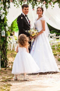 Gelin ve Damat Düğün üzerinde. Sevimli kız gül yaprakları uçan ile yeni evliler duş aldım.