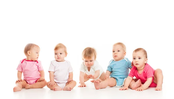 Grupo Bebés Ingeniosos Sentados Diferentes Ropas Aislados Sobre Fondo Blanco — Foto de Stock