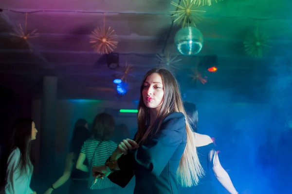Woman dancing in the night club - dancing friends at the background