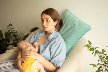 Anne ve bebek sandalyede. Beşikte emzirme pozisyonu