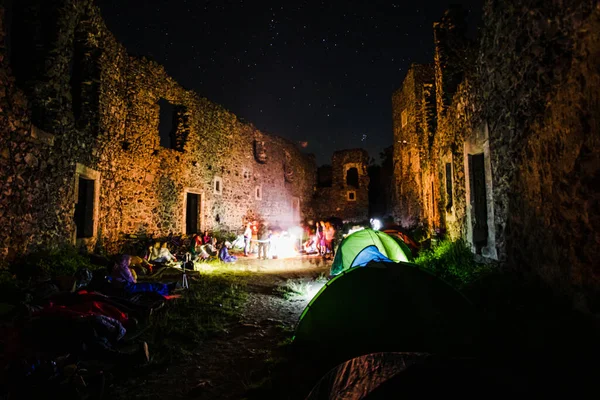 Night camping. Hikers stands and enjoying the beautiful night sky with stars