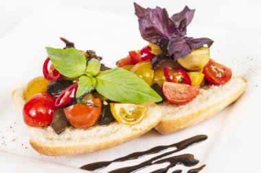 taze ekmek üzerinde sulu domates, pesto tepesi olarak