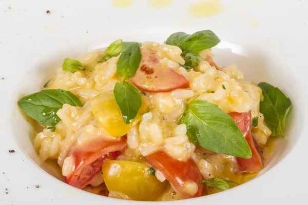Foto de delicioso plato de risotto con hierbas y tomate en blanco b — Foto de Stock