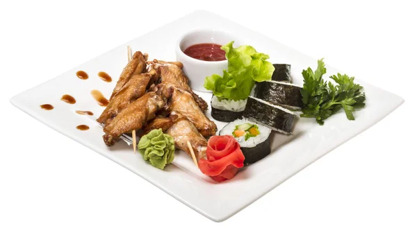 Buffalo chicken wings on plate with sushi — Stock Photo, Image