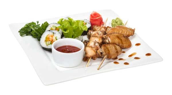 Asas de frango Buffalo no prato com sushi — Fotografia de Stock