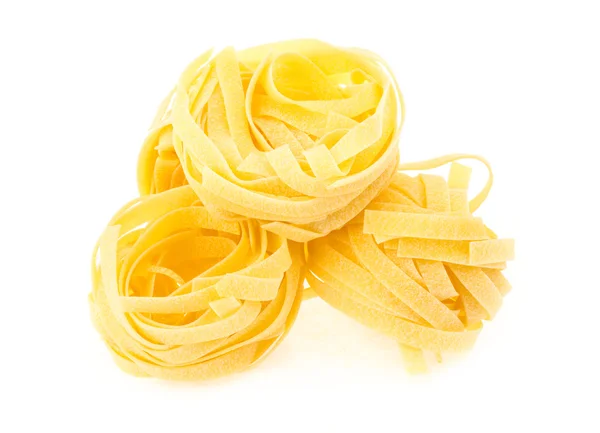 Nido di fettuccine di pasta isolata su fondo bianco — Foto Stock