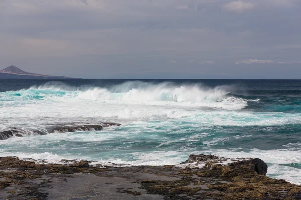 Ondas oceânicas turbulentas com espuma branca batem pedras costeiras — Fotografia de Stock