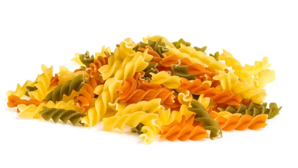 Ongekookte pasta fusilli in verschillende kleuren, witte achtergrond — Stockfoto