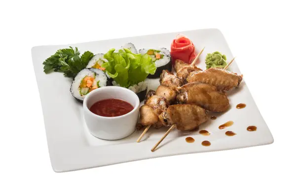 Buffalo chicken wings on plate with sushi — Stock Photo, Image