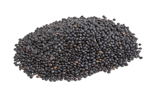 Heap de lentilha preta isolada em branco — Fotografia de Stock