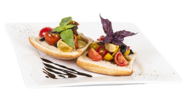 taze ekmek üzerinde sulu domates, pesto tepesi olarak