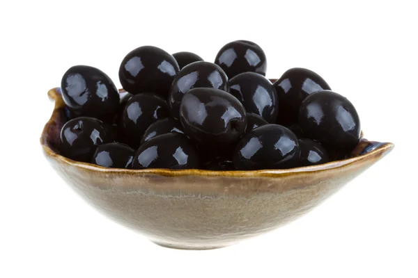 Olive nere innaffiate con olio d'oliva in una ciotola isolata su una zuppiera — Foto Stock