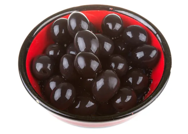 Azeitonas pretas regadas com azeite em uma tigela isolada em um whit — Fotografia de Stock