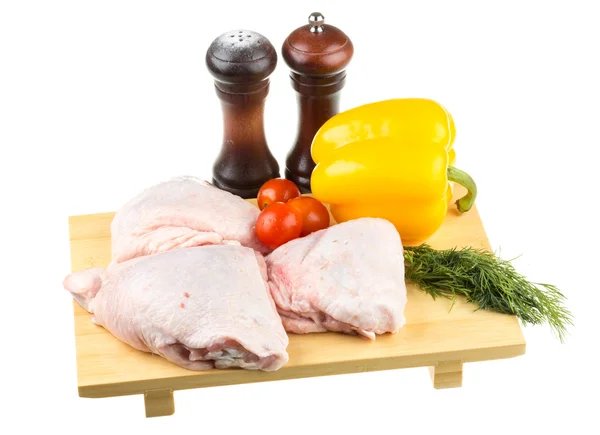 Fresh raw chicken wings on chopping board with roma tomatoes — Stock Photo, Image