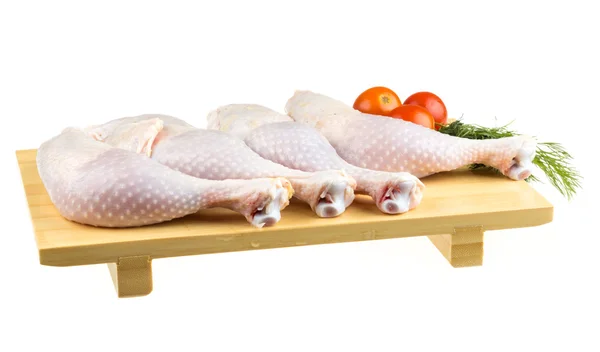 Fresh raw chicken wings on chopping board with roma tomatoes — Stock Photo, Image