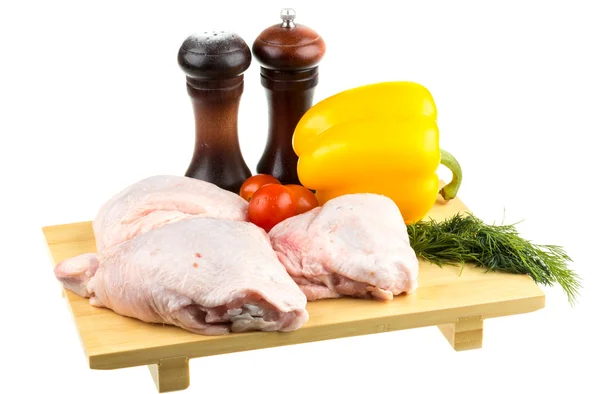 Alas frescas de pollo crudo en la tabla de cortar con tomates roma —  Fotos de Stock