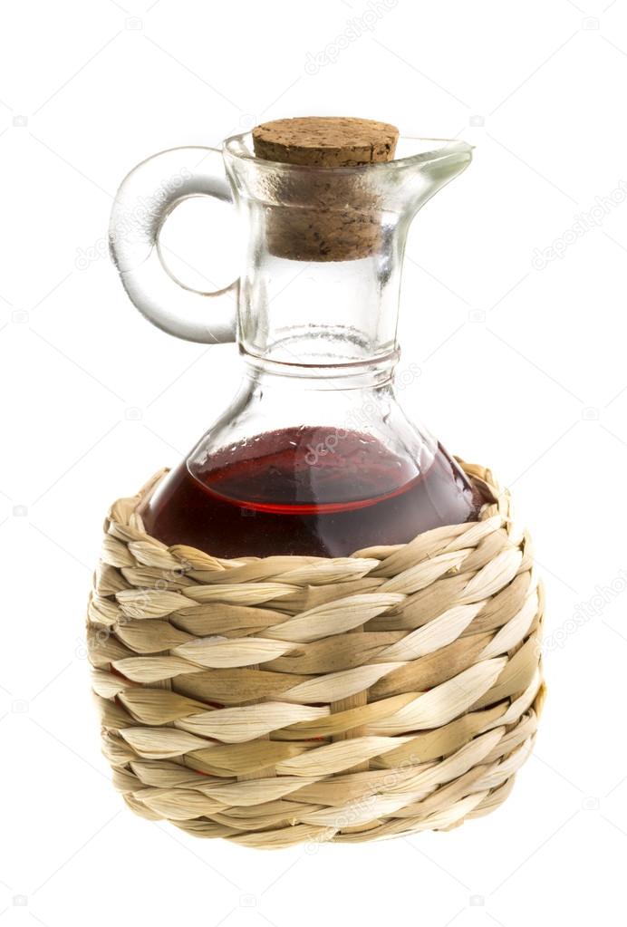 Small decanter with red wine vinegar isolated on the white