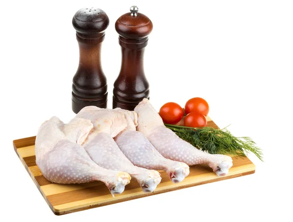 Verse rauwe kippenvleugels op hakken bord met roma tomaten — Stockfoto