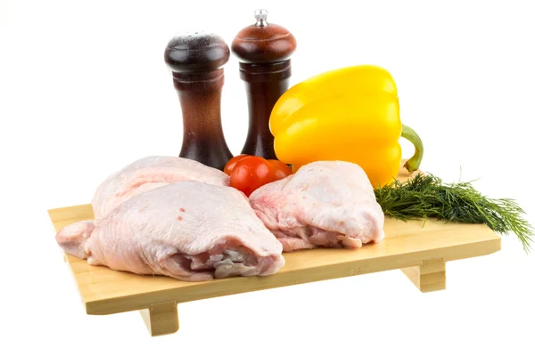 Alas frescas de pollo crudo en la tabla de cortar con tomates roma —  Fotos de Stock