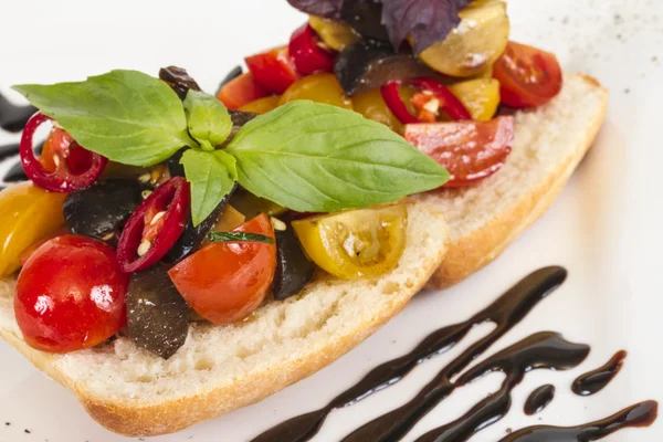 Pomodori succosi sul pane fresco, pesto come condimento — Foto Stock