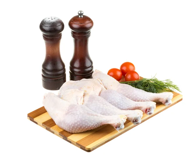 Fresh raw chicken wings on chopping board with roma tomatoes — Stock Photo, Image