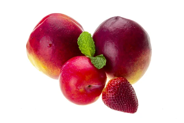 Dojrzałe brzoskwinie jasne, śliwki, truskawki i mięty — Zdjęcie stockowe