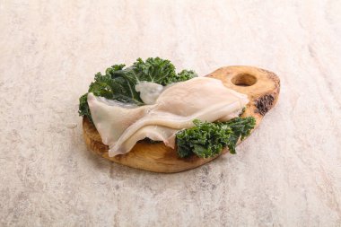 Ahşap tahtada pişirmek için çiğ mürekkep balığı