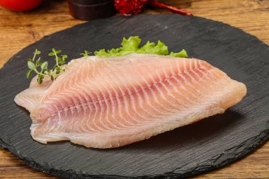 Pişirmek için çiğ tilapia balığı filetosu.