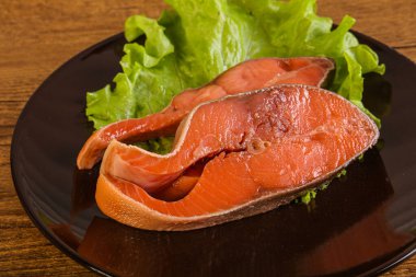 İki pembe somon balığı bifteği. Salata yaprağı.