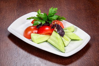 Dilimlenmiş sebzeli salata - domates, salatalık ve maydanoz