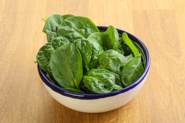 Tahta arka planda taze yeşil ıspanak yaprakları var.