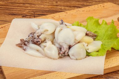 Çiğ deniz ürünleri, güvertede pişirmek için mürekkep balığı.