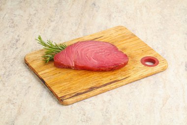 Teknede pişirmek için çiğ ton balığı bifteği. Biberiye servis ediliyor.