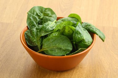 Tahta arka planda taze yeşil ıspanak yaprakları var.