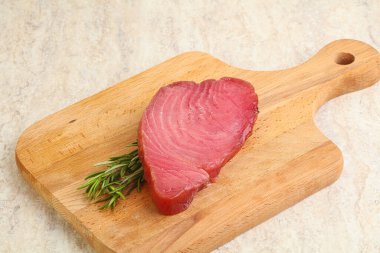 Teknede pişirmek için çiğ ton balığı bifteği. Biberiye servis ediliyor.