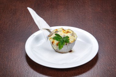 Makarna ve peynirli Cocotte maydanoz servis eder.