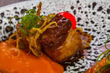 Fırında domuz, havuç sosu ve kızarmış soğan.