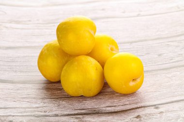 Arkaplanda olgun sarı erik yığını