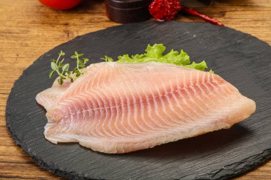 Pişirmek için çiğ tilapia balığı filetosu.