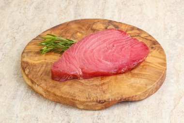 Teknede pişirmek için çiğ ton balığı bifteği. Biberiye servis ediliyor.