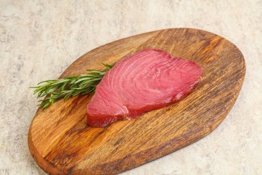 Teknede pişirmek için çiğ ton balığı bifteği. Biberiye servis ediliyor.