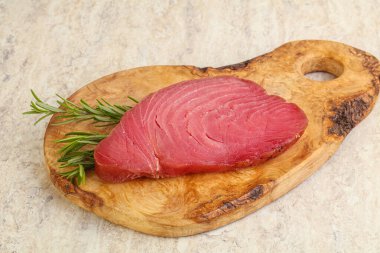 Teknede pişirmek için çiğ ton balığı bifteği. Biberiye servis ediliyor.