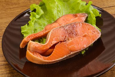 İki pembe somon balığı bifteği. Salata yaprağı.