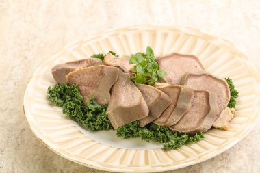 Dilimlenmiş domuz dili aperatifi. Fesleğen servis edildi.