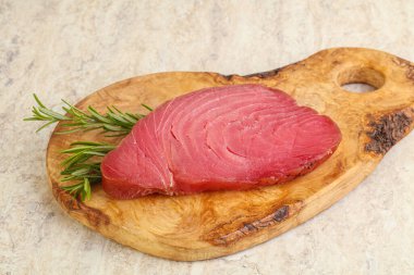 Teknede pişirmek için çiğ ton balığı bifteği. Biberiye servis ediliyor.