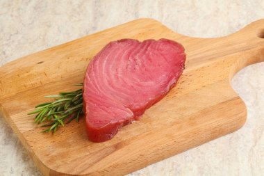 Teknede pişirmek için çiğ ton balığı bifteği. Biberiye servis ediliyor.