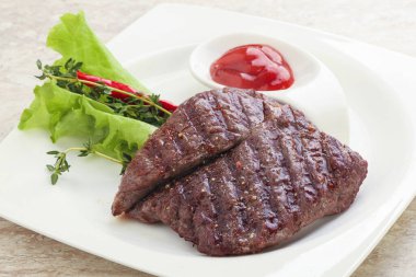 Izgara pala etekli biftek kekik ve ketçap servis edilir.